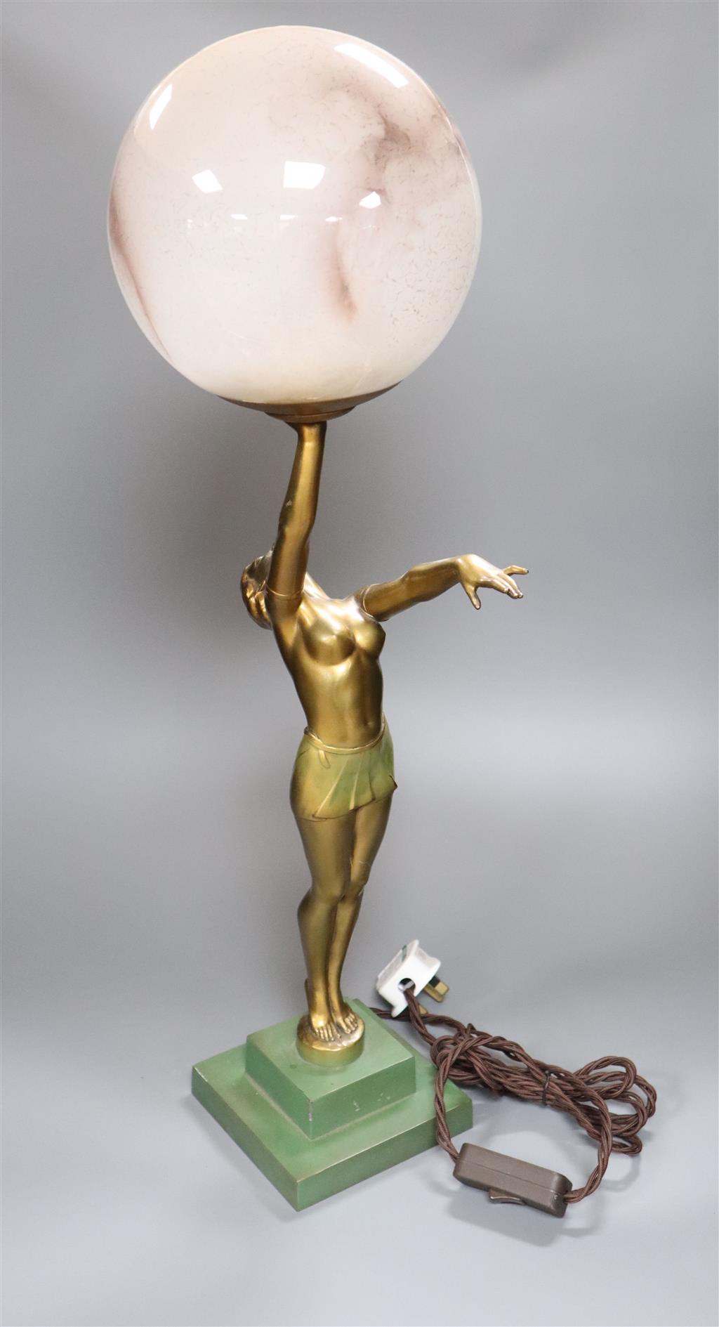 An Art Deco spelter figural table lamp, with semi-nude dancer holding a glass shade aloft, 64cm overall